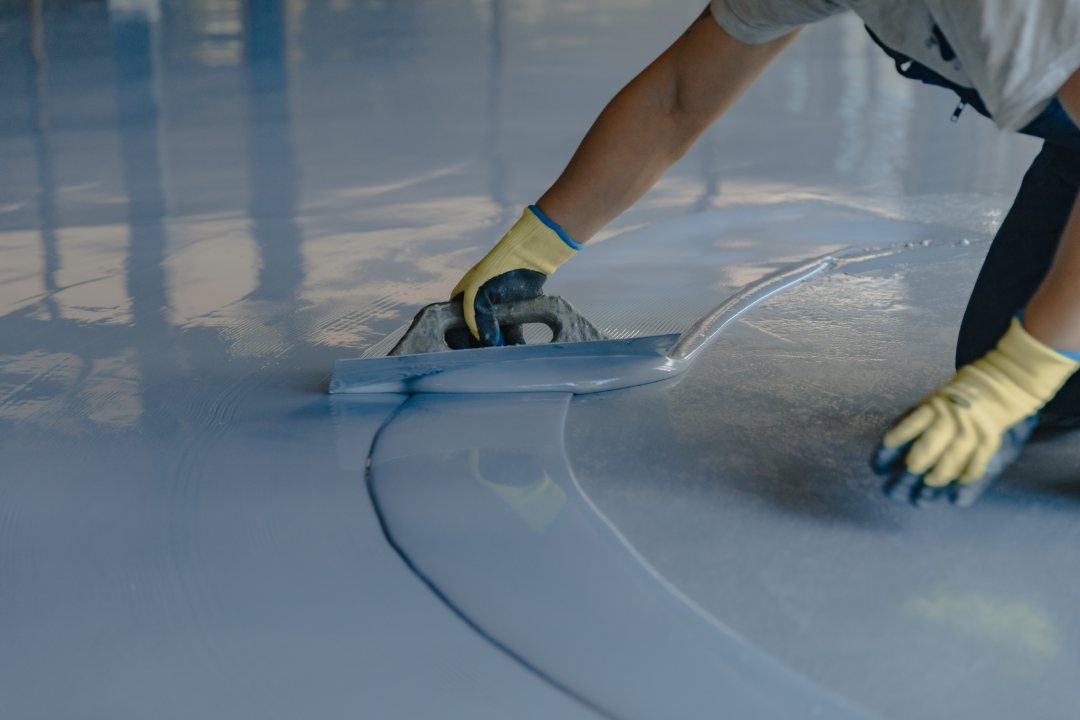 Profesional aplicando pintura en un suelo